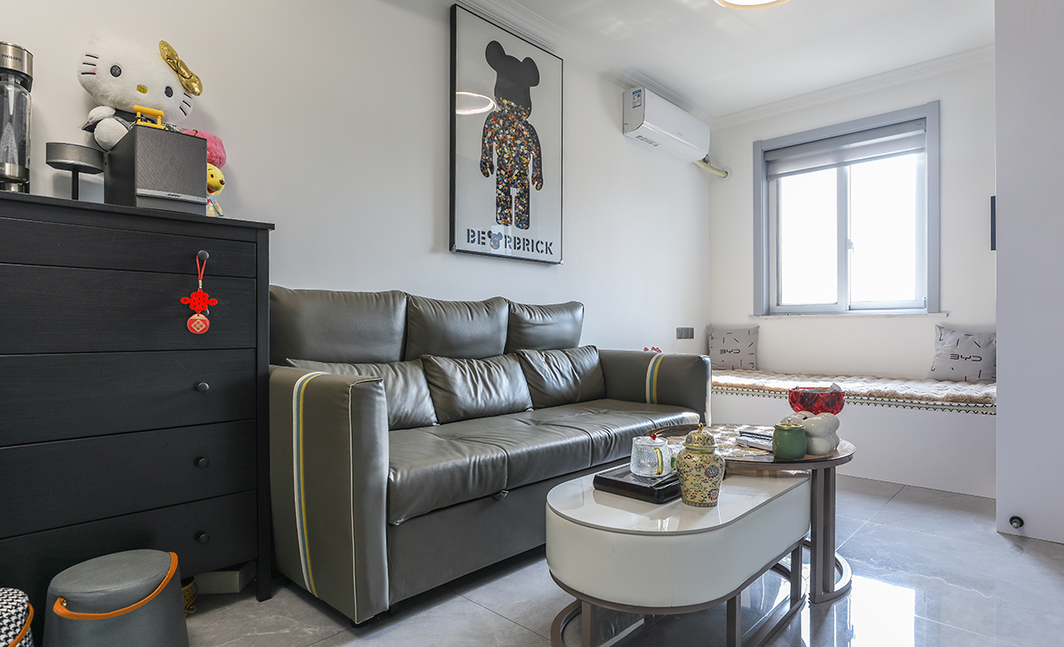 沙發(fā)用了皮質(zhì)沙發(fā)，沙發(fā)背景留白設(shè)計，色調(diào)上墻面涂料用淺色，沙發(fā)用深色，深淺搭配的錯落有致，既溫馨又簡潔。