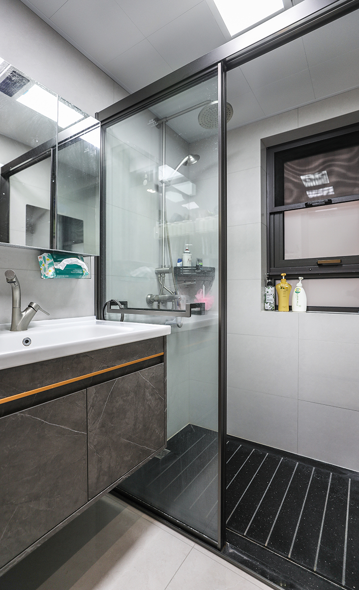 衛生間不大，但很緊湊，槍灰色的淋浴房、龍頭、花灑，墻地一體的瓷磚、白色的集成吊頂，淋浴房內黑色天然大理石防滑地面，無不體現主人高檔次的生活品味和優雅的審美觀。
