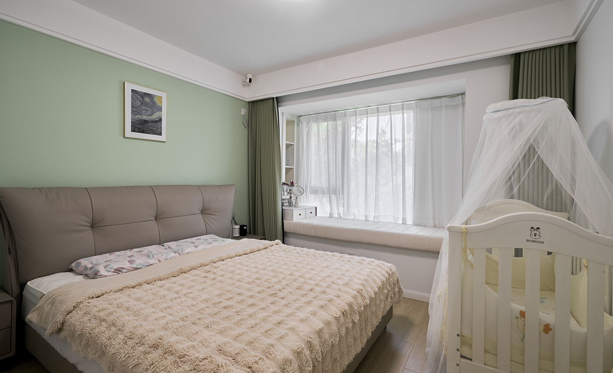 　　主臥床頭背景綠色，地面用胡桃色，L型大飄窗讓臥室空間具有延伸感，射燈把整個空間點綴地豐富、有質(zhì)感