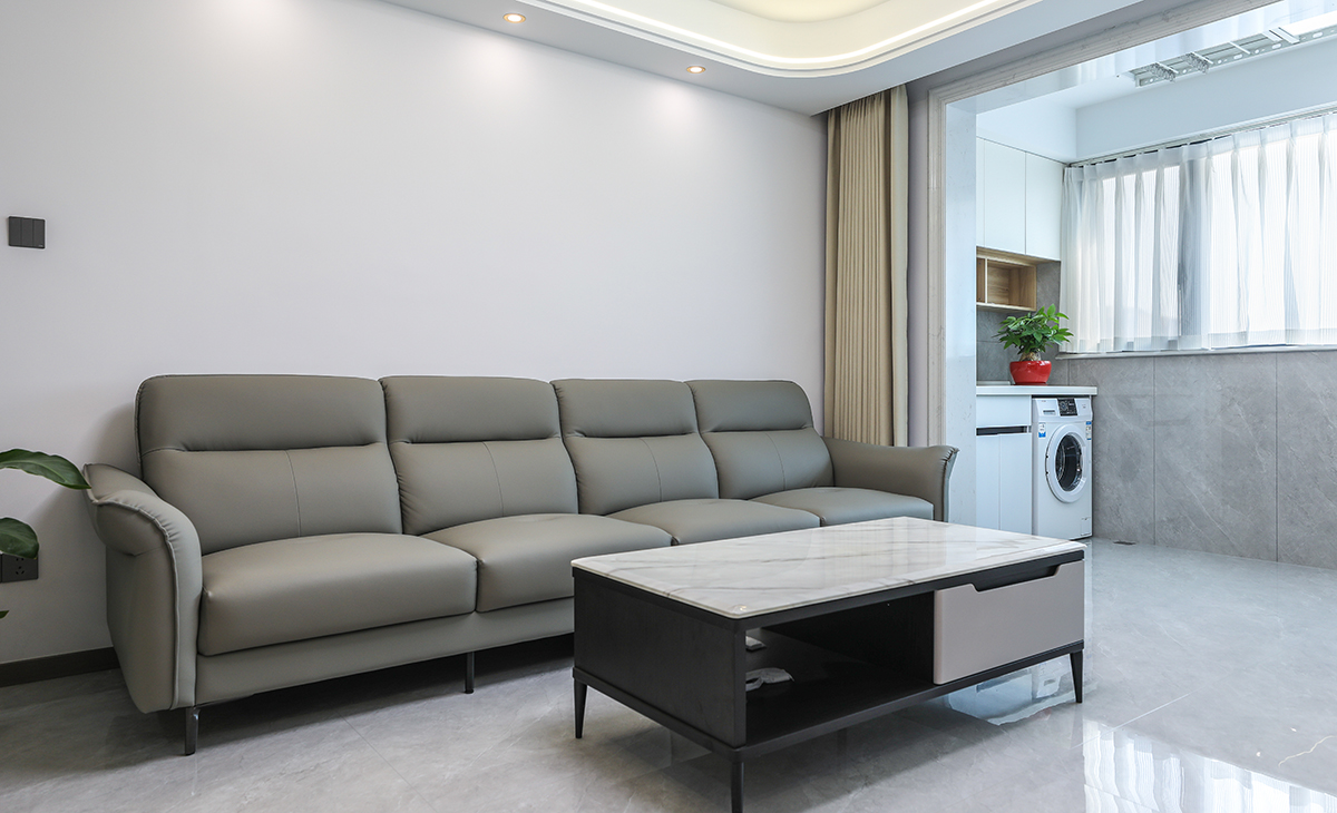 沙發背景刷米灰色涂料，白色的沙簾，沙發背景留白設計，色調上墻面涂料和窗簾用淺色，沙發用深色，深淺搭配的錯落有致，既溫馨又簡潔。
