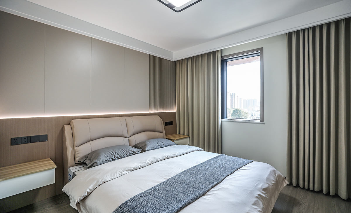 次臥和主臥空間基本一樣整體做的格柵床頭背景搭配床頭背景燈，頂部做的雙眼皮走邊搭配木地板整體讓人感覺溫馨舒適。
