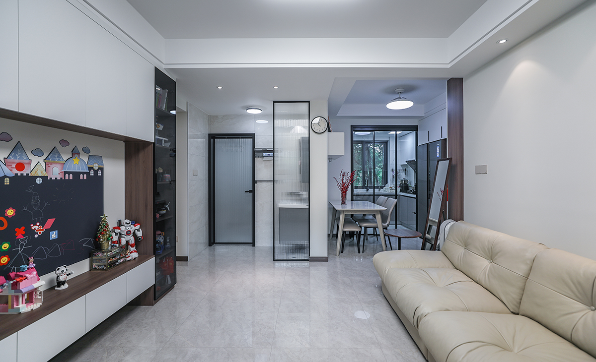 餐廳空間比較方正寬敞，聯(lián)通廚房的位置做三聯(lián)動(dòng)推拉移門，放大了空間感，靠墻做嵌入式冰箱，既實(shí)用、又有裝飾功能，原木色框架和白色木門板相呼應(yīng)，巖板餐桌把用餐氛圍調(diào)和的很溫暖，淺灰色地磚很干凈，色彩和造型上都簡(jiǎn)潔大氣。