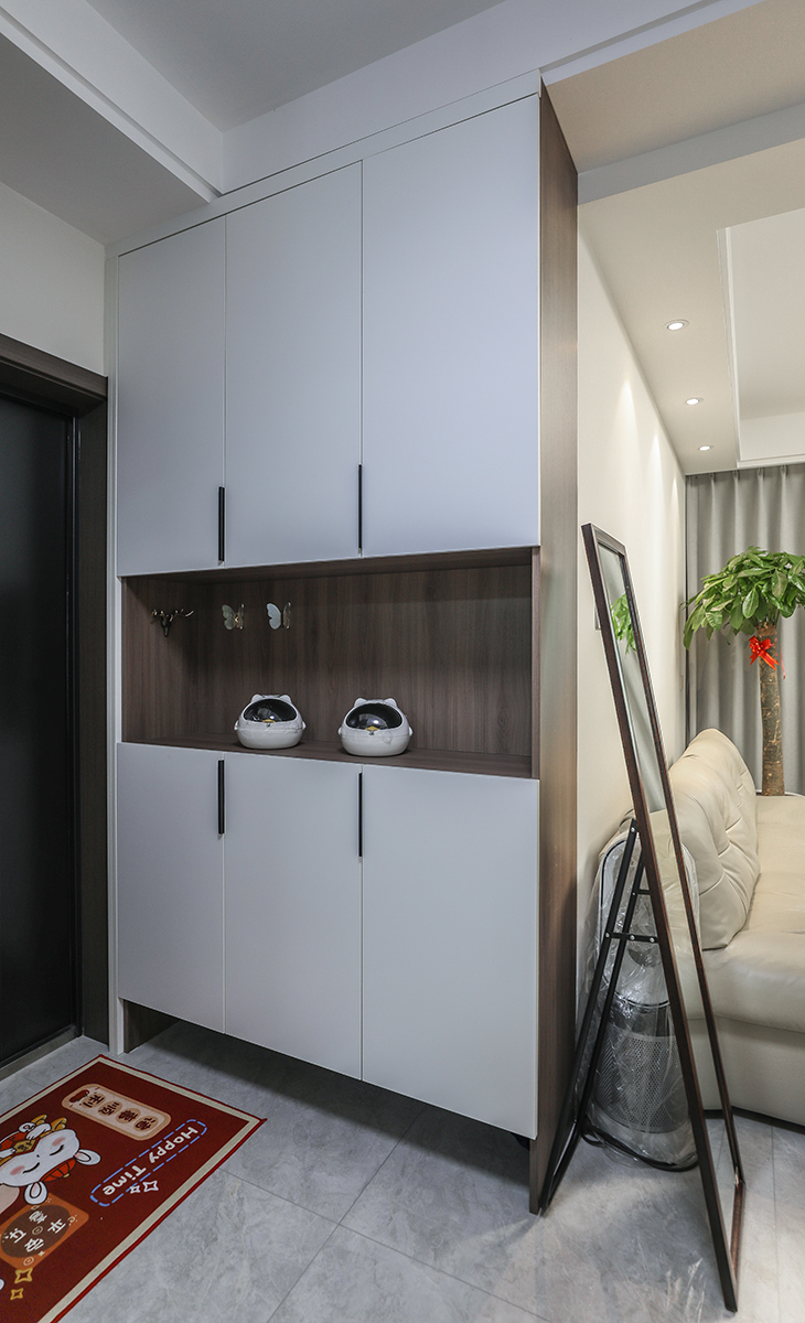 本套房子的走道儲(chǔ)物柜設(shè)計(jì)也是一大亮點(diǎn)，既實(shí)用，又有裝飾性，三門儲(chǔ)物柜，中間部分掏空，進(jìn)門可以放些鑰匙帽子之類的小物件，而柜體分成上下兩組，上層儲(chǔ)物，下層放鞋子，整體效果給人感覺不僅雅致而且有韻味。