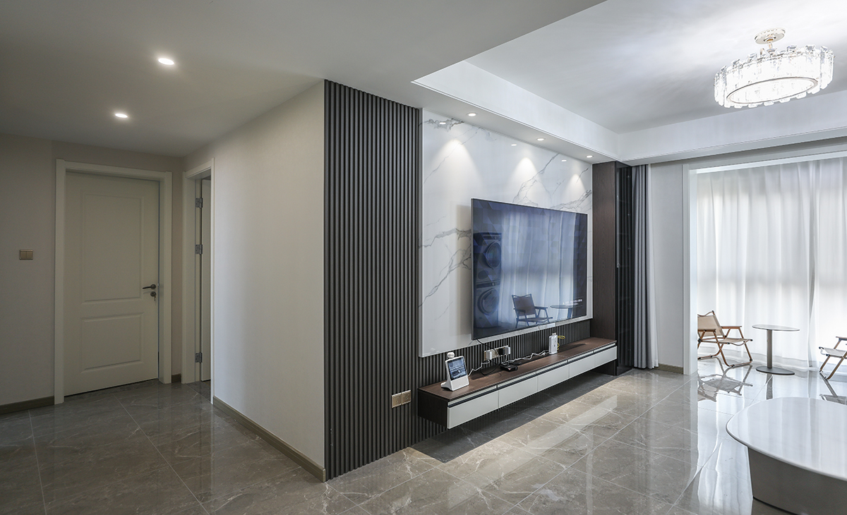 2400寬的巖板被頂上三個射燈點綴的恰到好處，電視柜兩邊的裝飾盆景作襯托，巖板臺面電視柜也很大氣，讓空間不但時尚而且清爽。