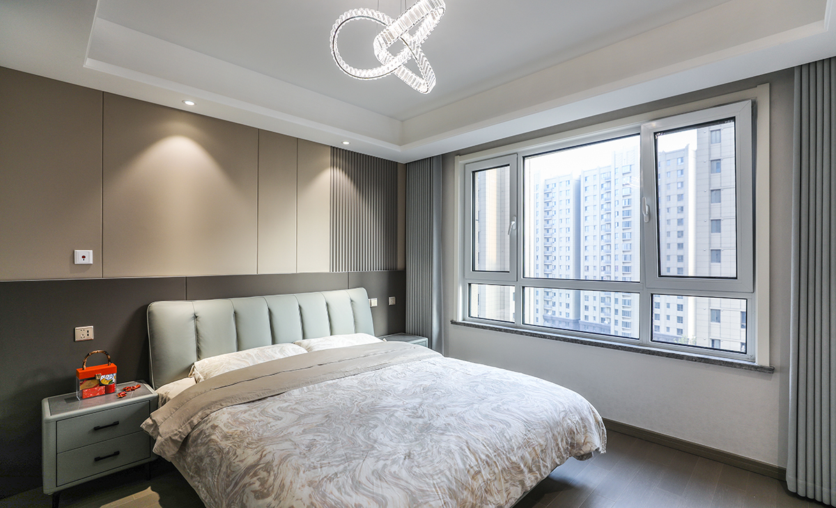 主臥原實木地板保留，所以床選擇的是深色，衣柜門板也是深色，這樣和原來的實木地板進行搭配，就不會那么突兀，頂面圓型吊扇燈，實現方中有圓，圓中有方，造型以簡潔平板為主，方便打理，體現了簡約風格的簡潔、隨意，不拘一格。