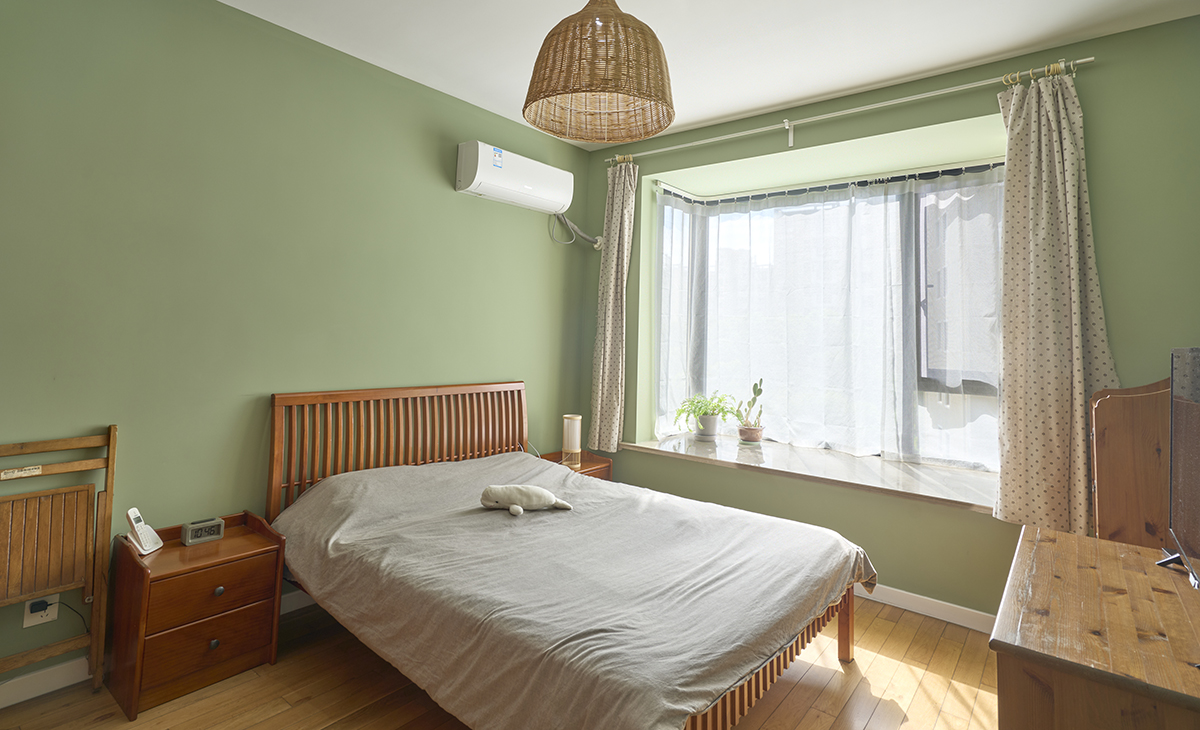 主臥床頭背景綠色，地面用胡桃色，L型大飄窗讓臥室空間具有延伸感，射燈把整個(gè)空間點(diǎn)綴地豐富、有質(zhì)感