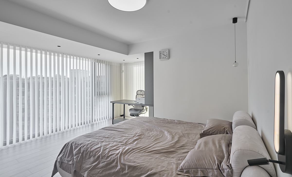 主臥和東陽臺打通，空間很大，三面窗，視線很寬廣，書桌和梳妝臺，衣柜展示柜都很大，儲物空間很多，灰色床單、灰色地板，淺灰色的柜子，讓整個空間明亮和增大很多。