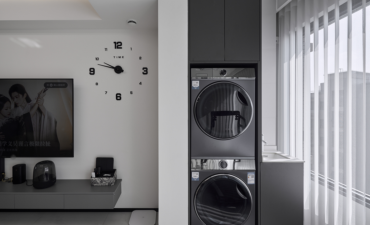 陽臺一邊放洗衣機、烘干機上方有吊柜，旁邊還能放一個小水池，方便主人洗溯，白色紗簾，讓陽光照進來很柔和。
