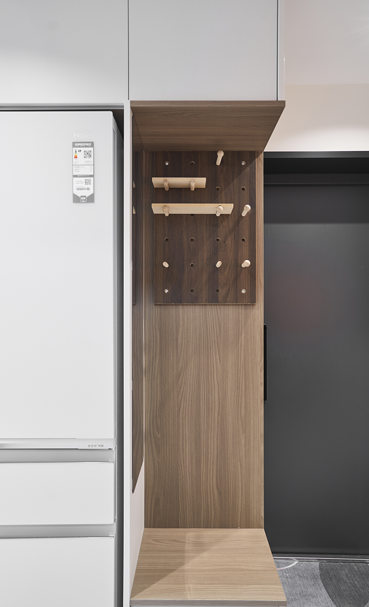 進門玄關柜，一邊是換鞋凳+掛衣區，一邊是鞋柜區，顏色用原木色+白色拼色，很自然，深灰色入戶門搭配，方便主人換鞋，實用功能超強。