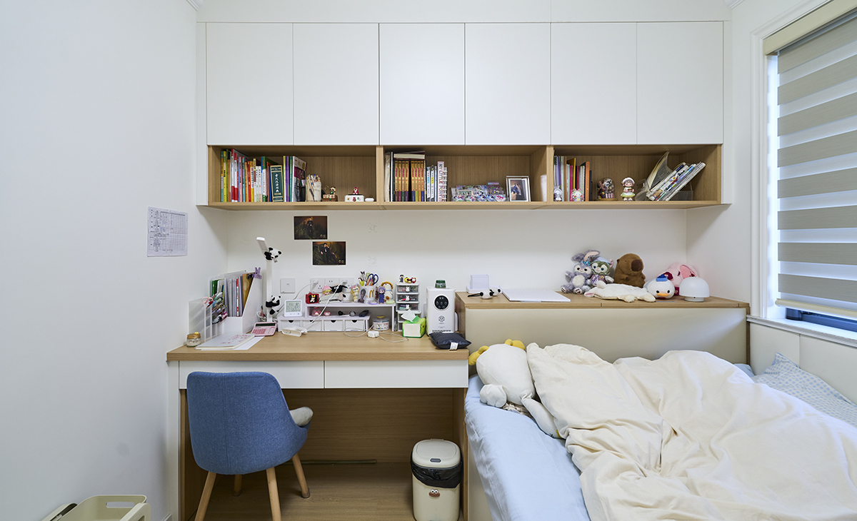次臥女兒房的設計。采用榻榻米和書桌及吊柜一體的設計
 
-房間左側有一張書桌，書桌上擺放著各種文具和裝飾品，如筆筒、文件夾、書籍和一些小擺件。書桌上方有一個開放式的書架，書架上整齊地擺放著許多書籍和一些裝飾品，包括相框和玩偶。
 房間右側是一張床，床上鋪著淺色的床單和被子，床頭有幾個毛絨玩具，營造出溫馨可愛的氛圍。
窗戶上裝有百葉窗，可以調節光線，既保證了采光，又能在需要時提供隱私保護。
4.?裝飾和細節
 
- 書桌旁邊有一把藍色的椅子，與房間整體色調相協調。
- 書桌下方有一個垃圾桶，方便日常使用。
- 墻上掛著一些裝飾畫和紙張，增添了房間的趣味性。
 
整體來看，這個次臥女兒房設計得非常溫馨和實用，既適合學習又適合休息，充滿了少女的氣息。。
