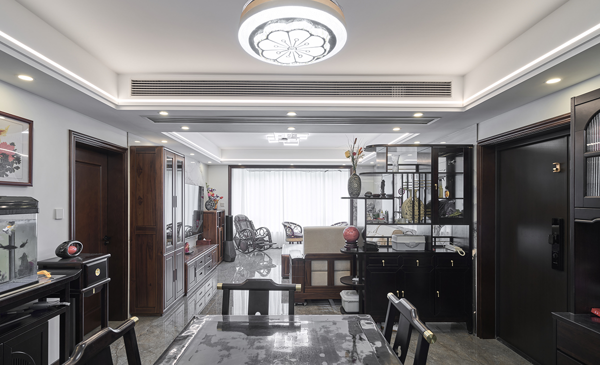 餐廳采用實木方桌，中式玄關，中式餐邊柜，體現中式風格的簡潔時尚，方正大氣、矮柜上的魚缸很有仙氣，頂面中式吊燈，配上線型燈，讓空間溫馨、大氣。