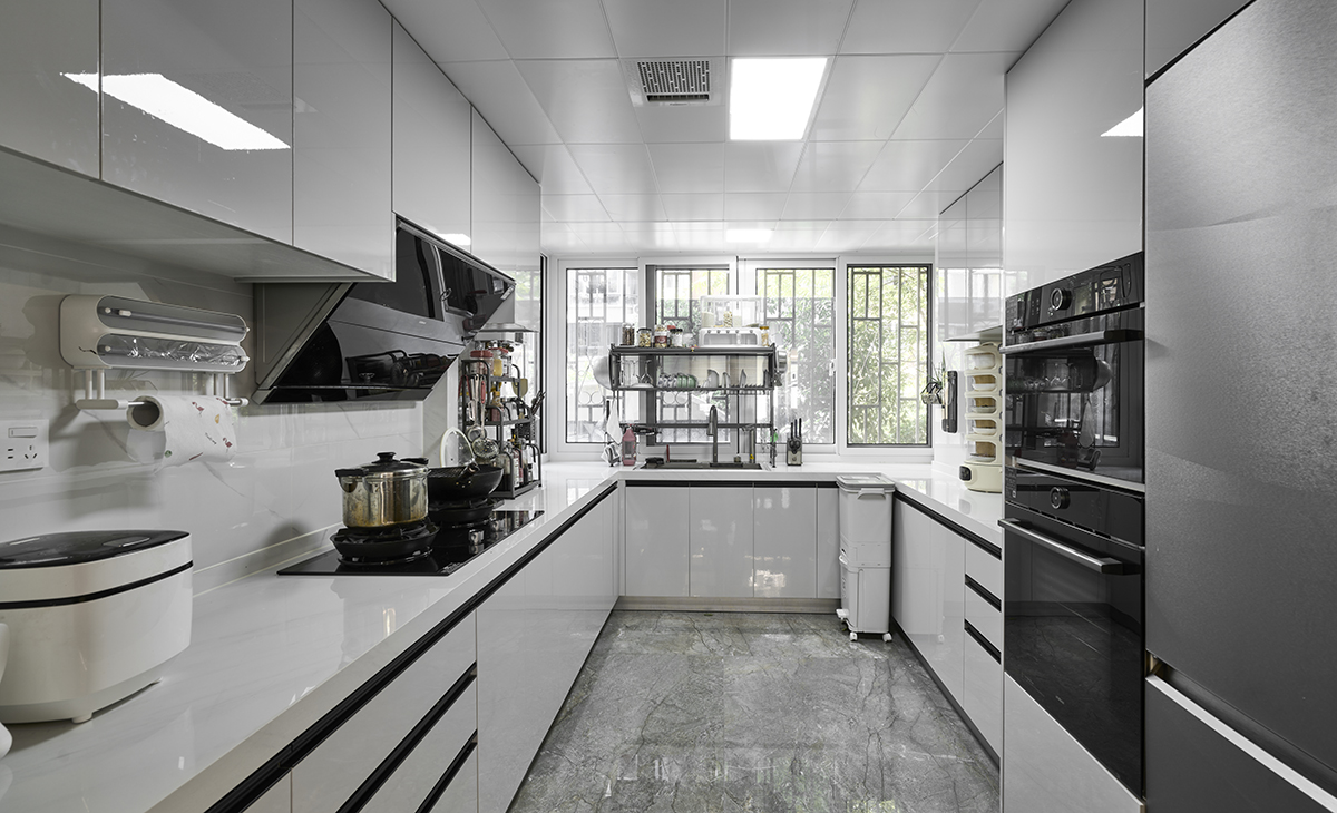 該套房子廚房空間很大，U字型櫥柜，洗碗機、蒸烤箱，微波爐等電器全配，兩排6個抽屜，上下柜都是白色，臺面白色，方便打理，墻地磚的顏色和櫥柜顏色搭配地很自然，客戶不斷地夸贊設計師對色彩的精準把握。