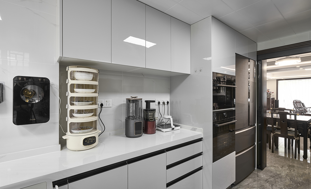 嵌入式冰箱和電器立柜完美組合，廚房移門可以全部收起來。深咖色地磚通鋪，白色臺面，讓廚房空間顏色明暗有序，從深到淺，色調很豐富。