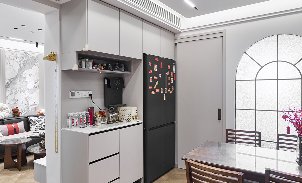 餐廳空間比較方正，冰箱和水吧臺連成一體，中間有管線機、頂面做了中央空調吊頂，雙眼皮圍邊的造型，玄關處的花瓶把空間點綴地恰到好處。