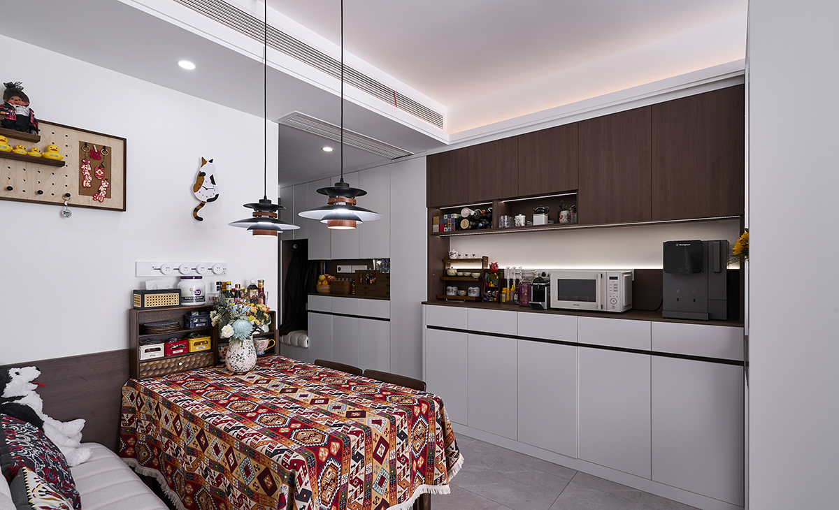 換鞋凳、鞋柜和餐廳柜連成一體，布局緊湊有致，餐邊柜暗藏燈帶，頂部暗藏燈帶，灰色地磚，整潔干凈，方便打理，餐桌頂面吊燈是一大亮點，把空間點綴地恰到好處。