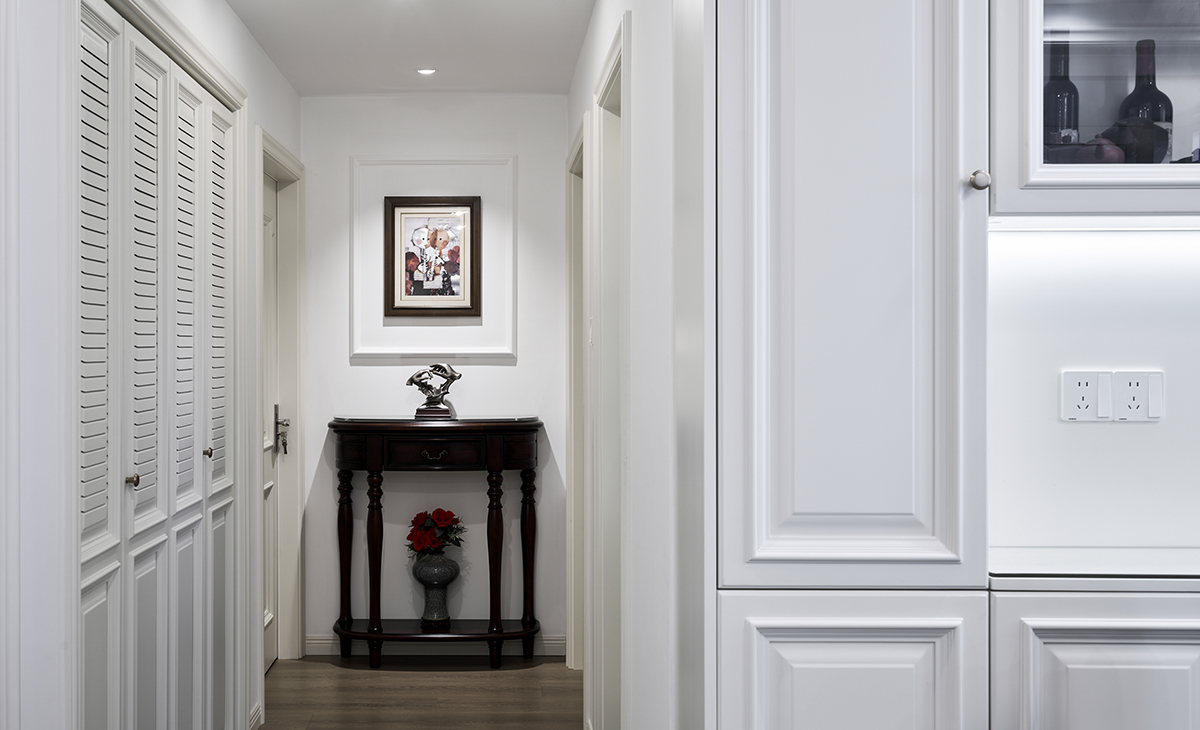 作為家的“臉面”，美式玄關會清晰地預告室內的風格。通過一張實木玄關柜、一幅標志性裝飾畫或一盞特色吊燈，在客人進門瞬間便傳達出家的整體氛圍。它高效地處理進出家門的關鍵動作：換鞋、置物、整理儀容。所有設計都圍繞這些行為展開，確保實用。同時，通過精心布置，將日常行為賦予一種歸家與外出的儀式感