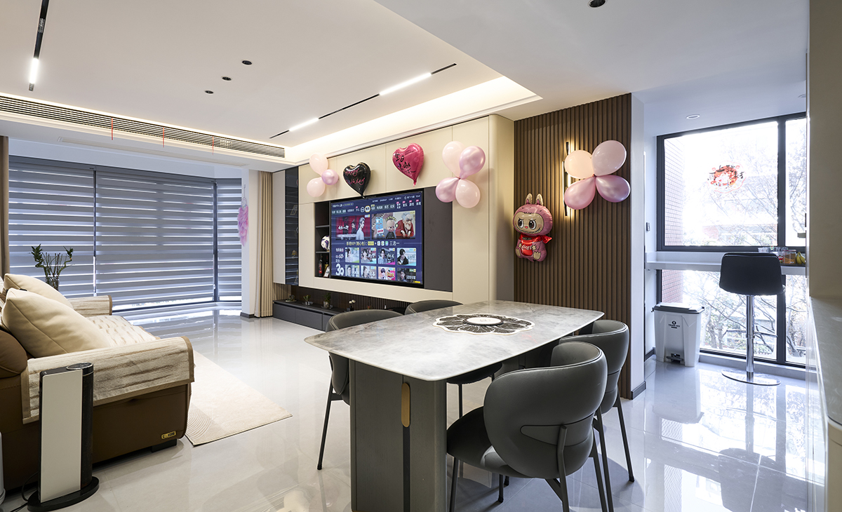 客廳是接待客人的空間、是家庭裝修的亮點(diǎn)所在、也是一家人活動(dòng)頻率最高的區(qū)域，棕色皮質(zhì)沙發(fā)，體現(xiàn)點(diǎn)亮空間，吊頂造型上采用無(wú)主燈設(shè)計(jì)+磁吸軌道燈，極致簡(jiǎn)約的氣息很濃。地面采用淺灰色地磚，沙發(fā)背景采用竹木木飾面墻板。造型和色調(diào)上無(wú)不給人華麗、簡(jiǎn)約、溫馨的氣息。