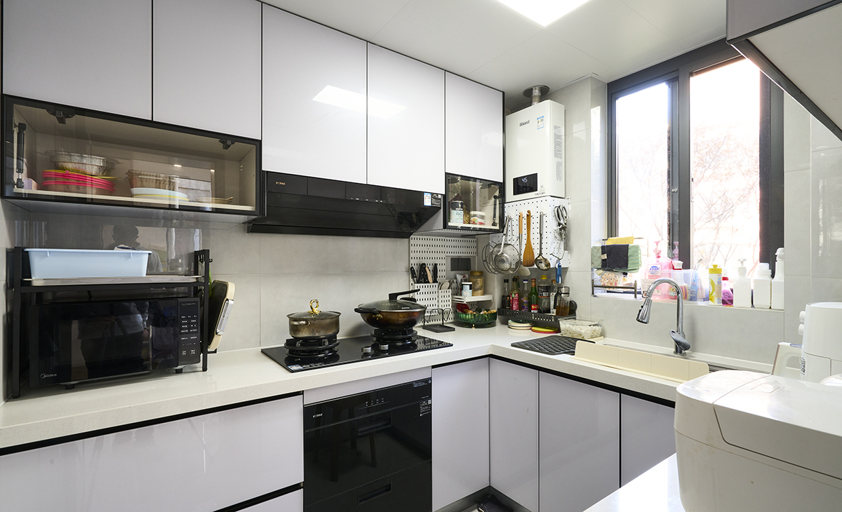 該套房子廚房空間很大，做成U字型櫥柜，蒸烤一體機(jī)放煤氣灶立柜中，煤氣灶下方配洗碗機(jī)，上柜下柜都是米白色，臺(tái)面白色，方便打理，墻地磚的顏色和櫥柜顏色搭配地很自然，客戶不斷地夸贊設(shè)計(jì)師對(duì)色彩的精準(zhǔn)把握。