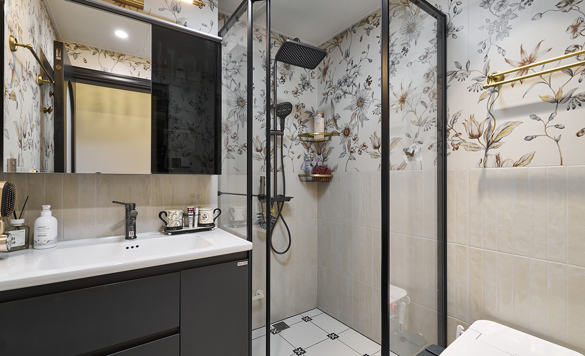 衛生間墻面鋪滿帶植物枝葉圖案的壁紙，復古基調搭配小清新色調，地面小花磚多樣化鋪貼，形成對比鮮明卻不沖突的視覺效果。  