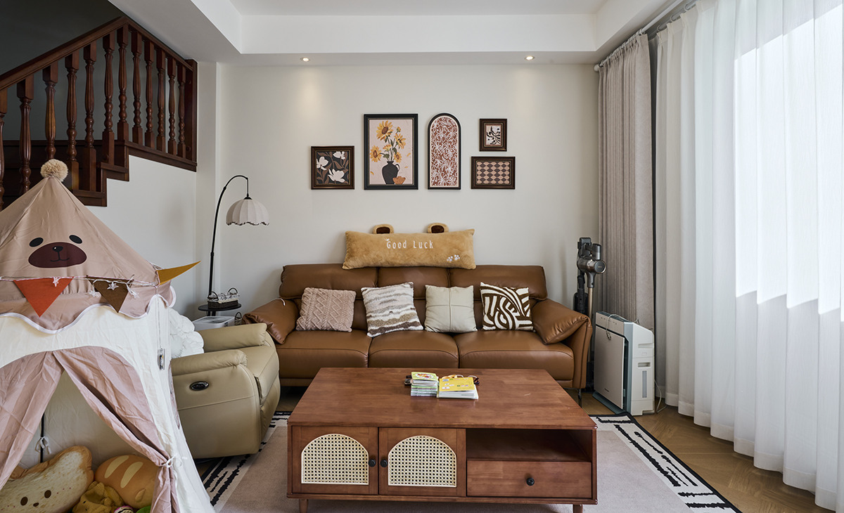 客廳是接待客人的空間、也是活動(dòng)相聚最多的地方。大地色的沙發(fā)，將復(fù)古花磚鋪進(jìn)客廳，再擺上一張木質(zhì)和茶幾，白墻為紙，木作為墨，幾幅小墨小品懸于壁上，亞麻窗簾隨風(fēng)輕擺，中古風(fēng)的雅致，在一呼一吸間悄然流淌。