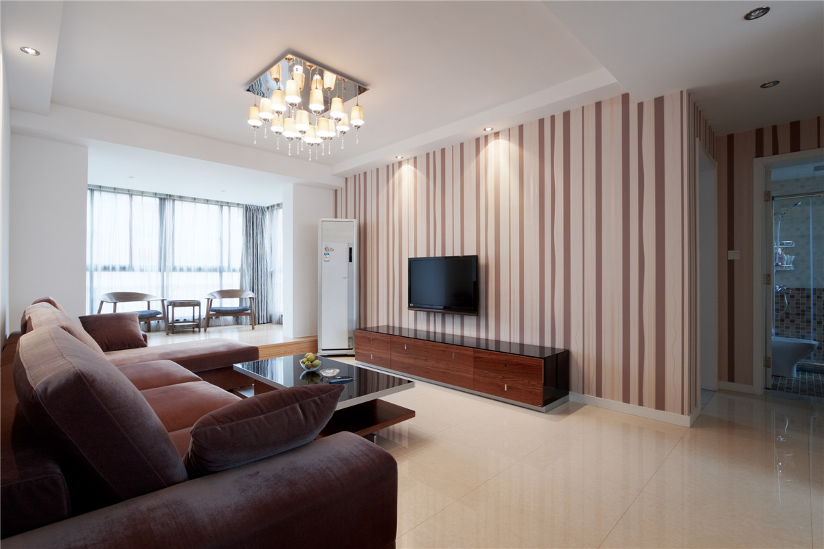 大片的落地窗不僅滿足了室內對光線的要求，也是都市生活的一種唯美體現，將不是很寬敞的陽臺與客廳用淡黃色的地磚連接在一起并將為一個休閑區(qū)使用，這大大的擴大了室內的空間感覺。
