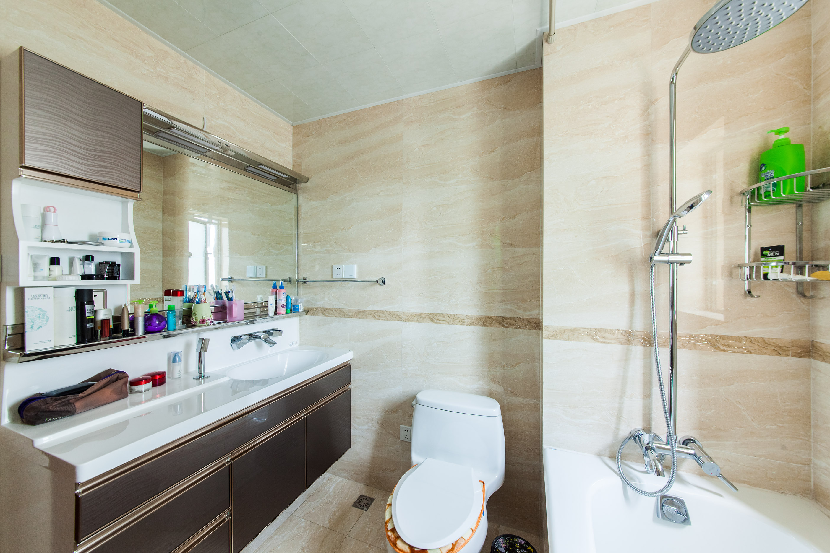 衛生間運用大理石文理的墻面磚，淺黃的磚，搭配上深色的臺盆柜，在滿足生活需求的同時，又不失現代簡約的設計基準。