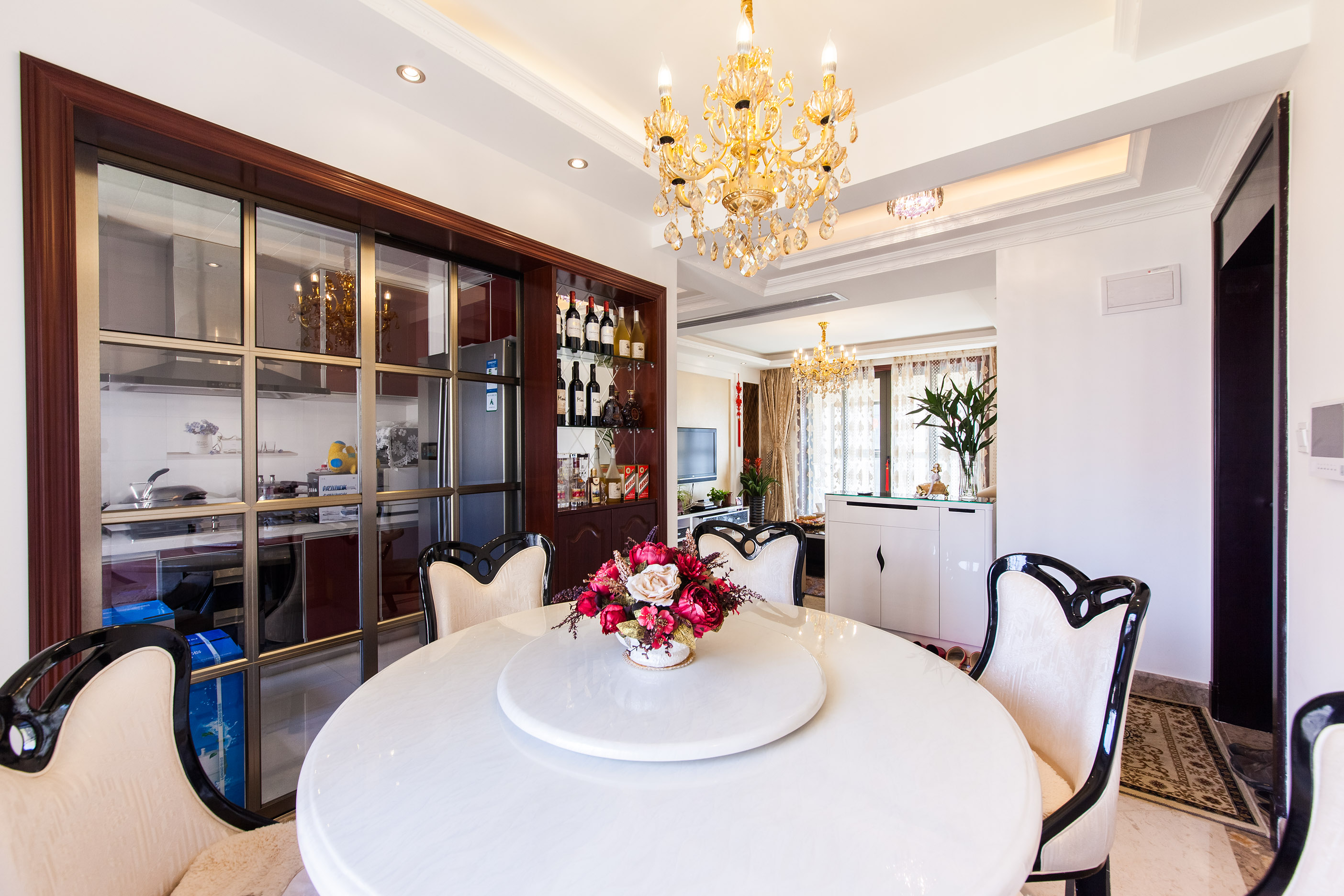 餐廳白色的餐桌，配上黑色邊框的餐椅，整體色調是那么的協調，紅木色的裝飾酒柜，顯現出業主的高尚品味，漂亮的水晶燈使得高貴的空間更加的濃烈。
