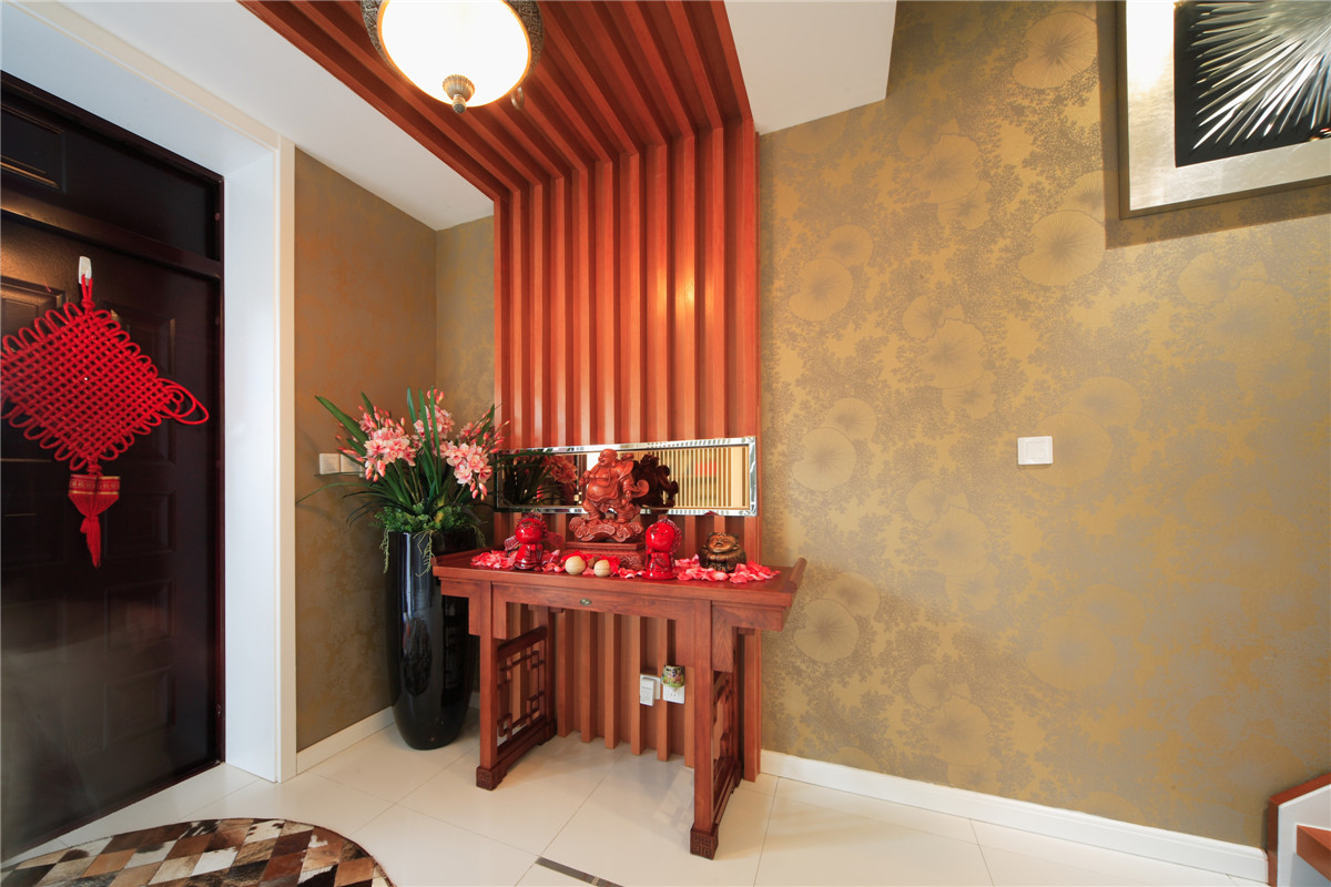 進門的玄關處采用了木飾面裝飾，對于業主是生意人的特性，設計了供臺位置，整個客廳的分水位在這里淋漓盡致。
