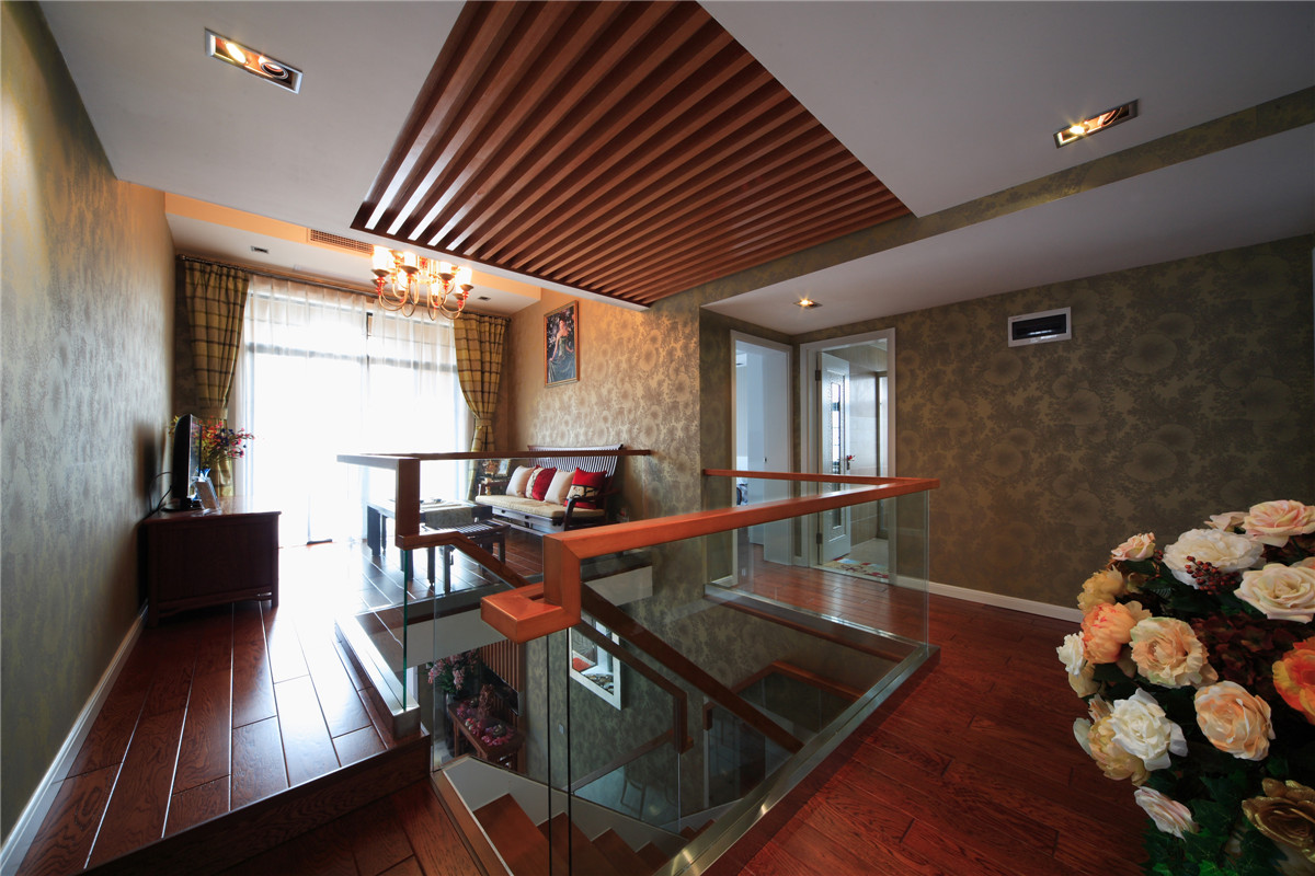 二樓的樓梯采用了鋼化玻璃和木結構，摒棄了傳統的實木結構，既時尚又大氣，配合著頂面的木飾面吊頂，相得益彰。