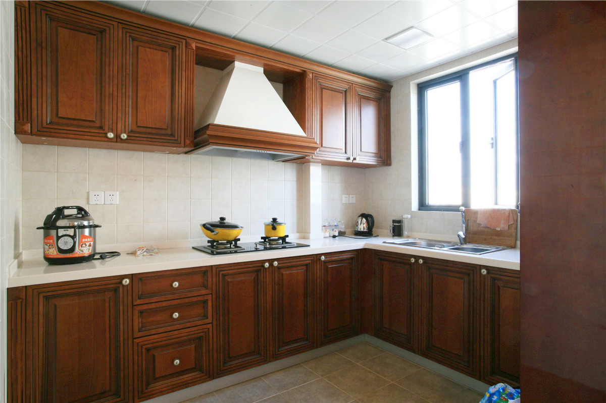 廚房間的整體櫥柜都有著西式的風(fēng)味，而且還帶有西式田園風(fēng)格。潔白的臺面，吸油煙機的半露再有邊框裝飾，就更加突出了。
