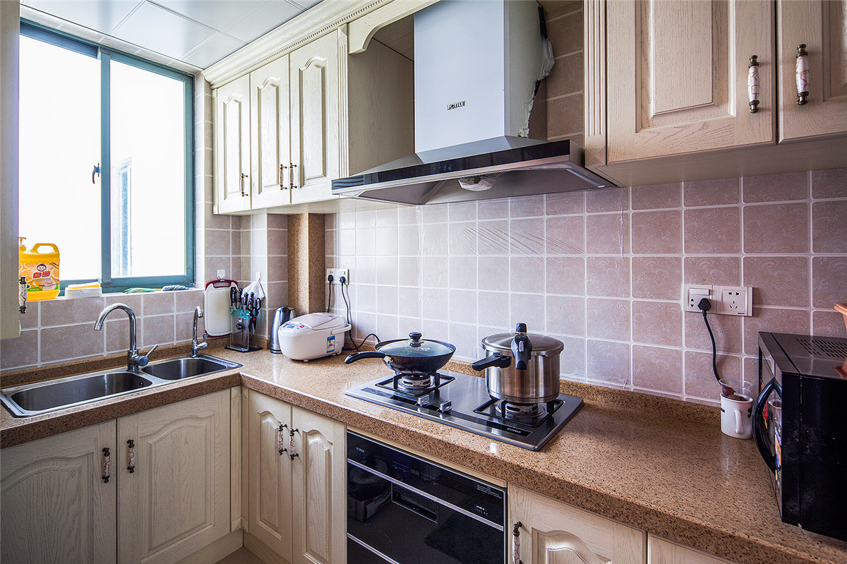 簡歐大氣、更貼近于自然，白色實木廚柜配套歐式墻磚，保留了材質、色彩的一致。
