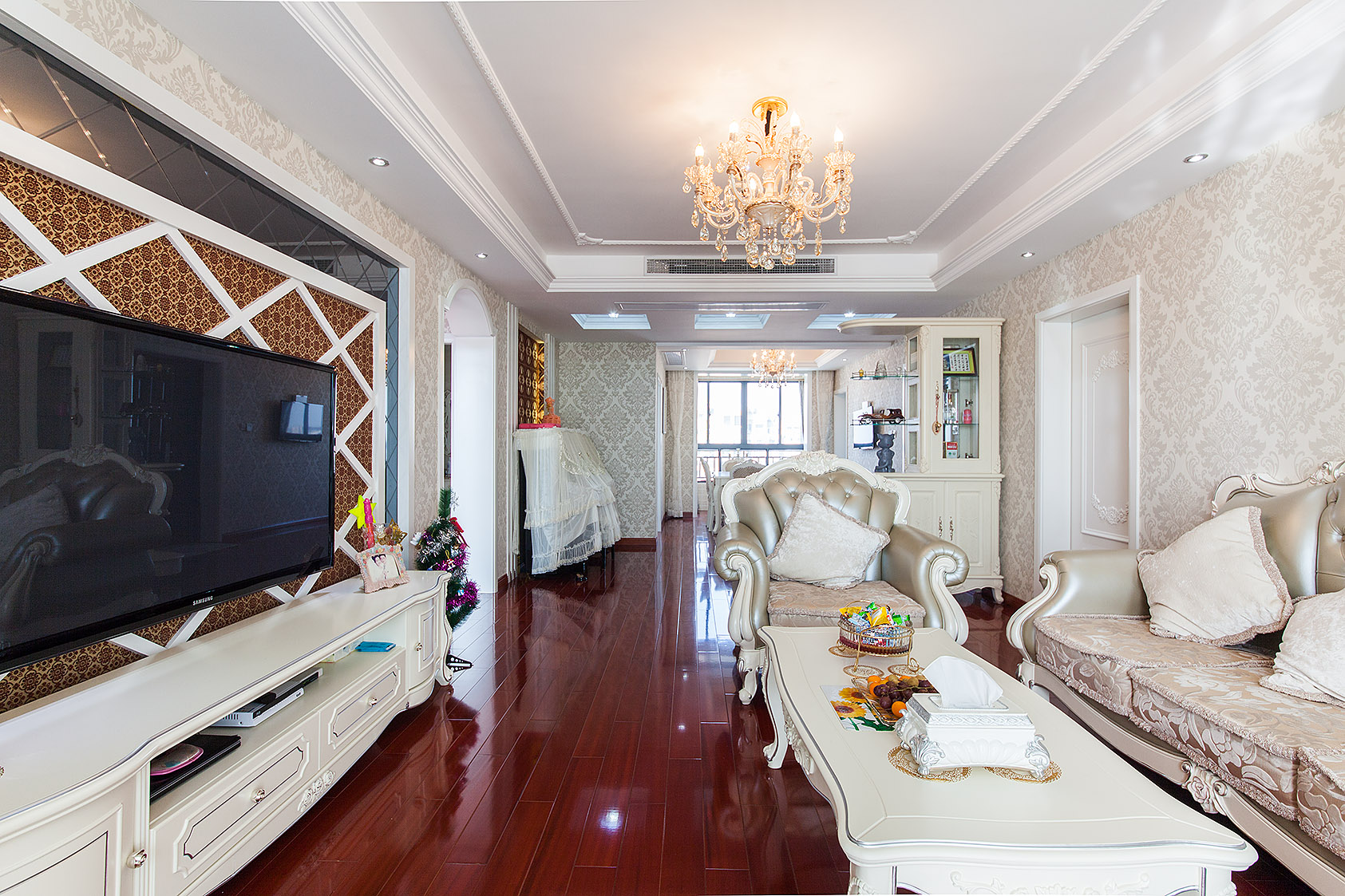 墻面暖色壁紙的處理，頂面角花的點(diǎn)綴還有電視背景細(xì)節(jié)的處理，把歐式細(xì)膩的味道烘托出來(lái)。
