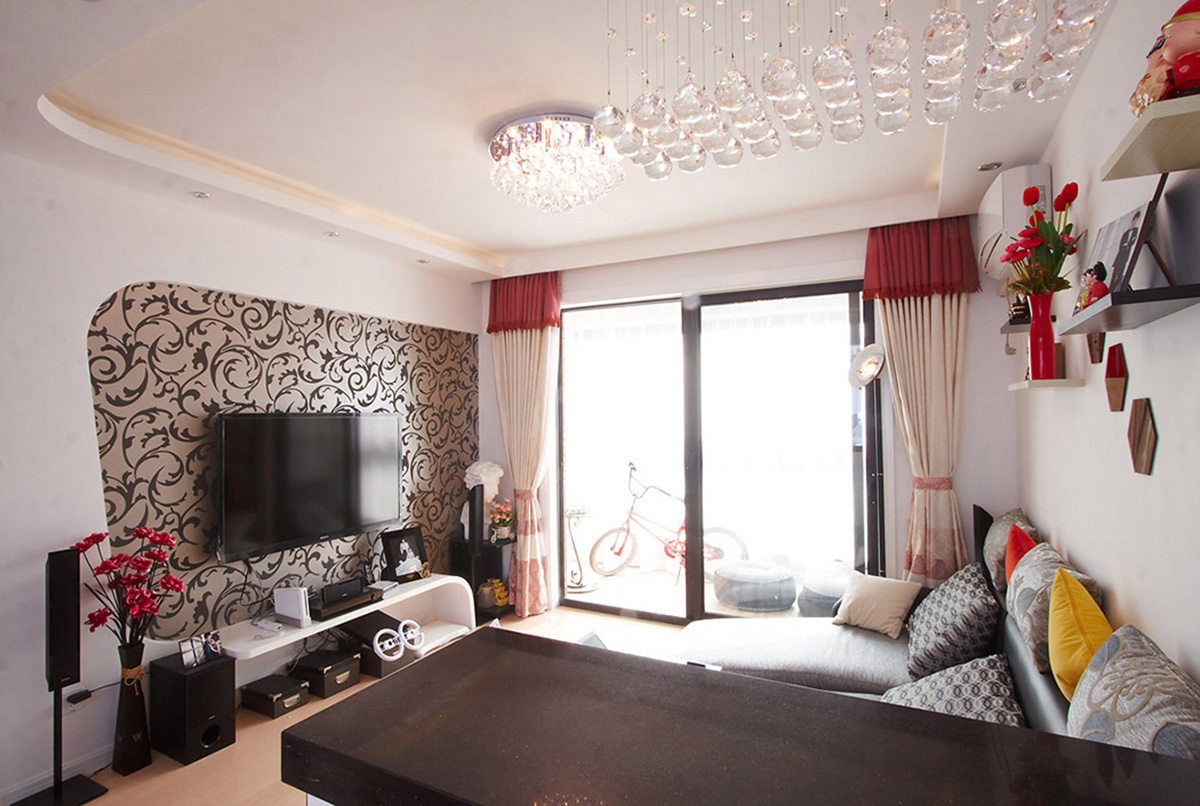 灰色布藝沙發(fā)簡潔、時尚，弧形的背景墻與弧形的電視柜，再配上灰色花紋墻紙，整體視覺顯得大氣而時尚。
