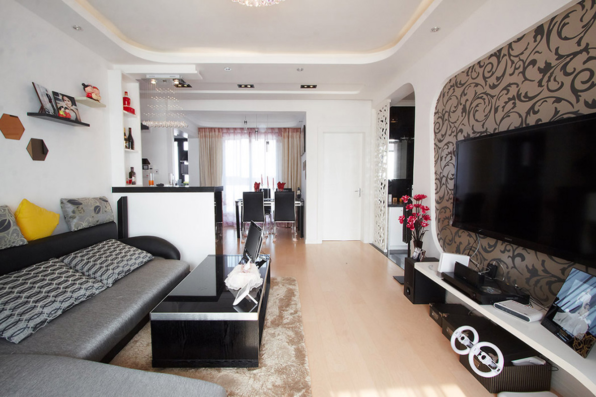 餐廳的家具與客廳形成呼應，吸人眼球的要數(shù)客廳的吧臺，也以黑白為基調，配上水晶燈，讓客廳的空間盡顯時尚。
