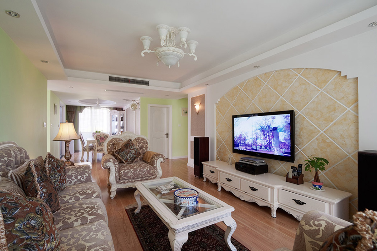 米色的背景墻和綠色的墻面形成強烈對比，厚重華美的復古風家具和白色吊燈，使客廳的空間清新又不失華貴。
