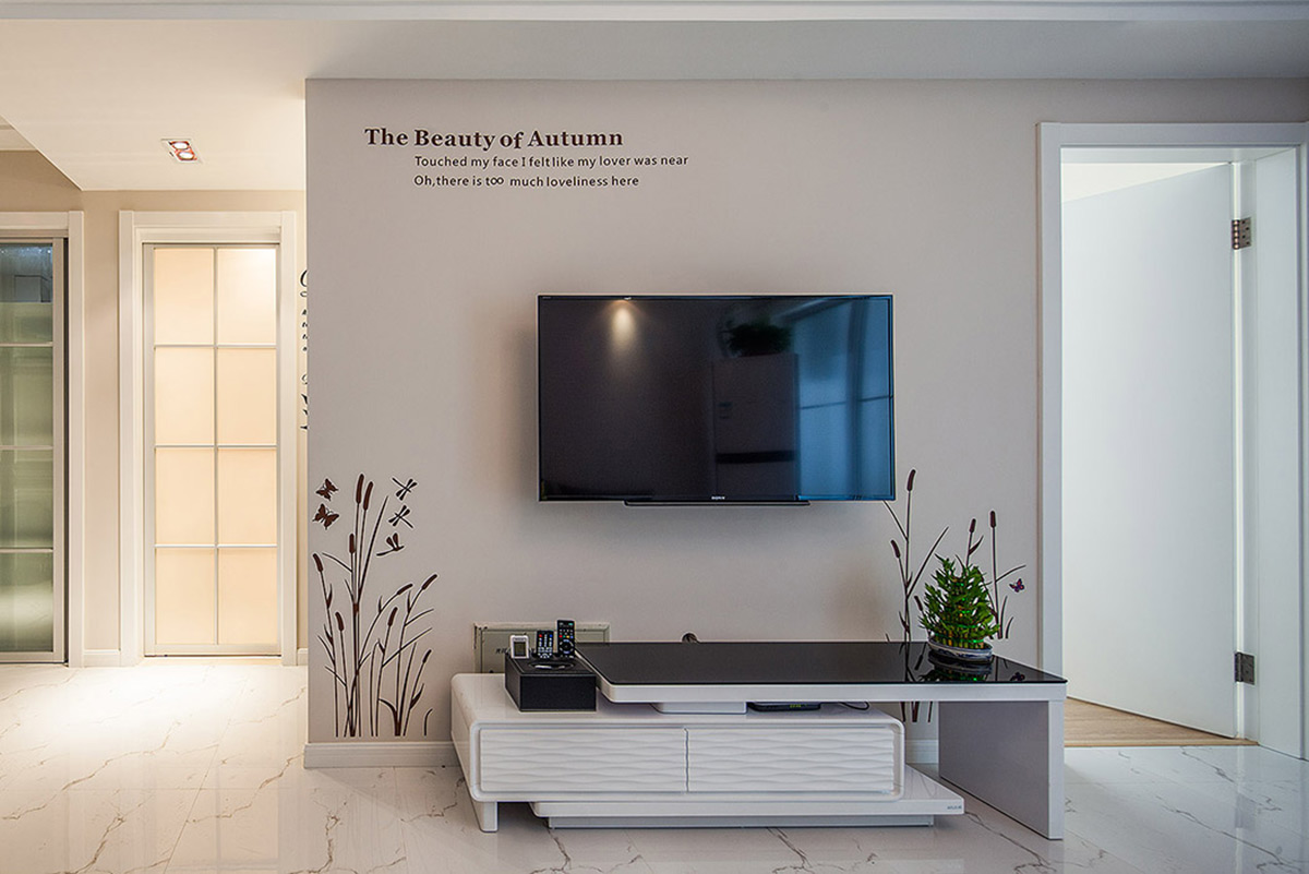 客廳背景墻原本面積不大，摒棄了原有復雜的墻紙，用局部的墻貼來處理，相得益彰。
