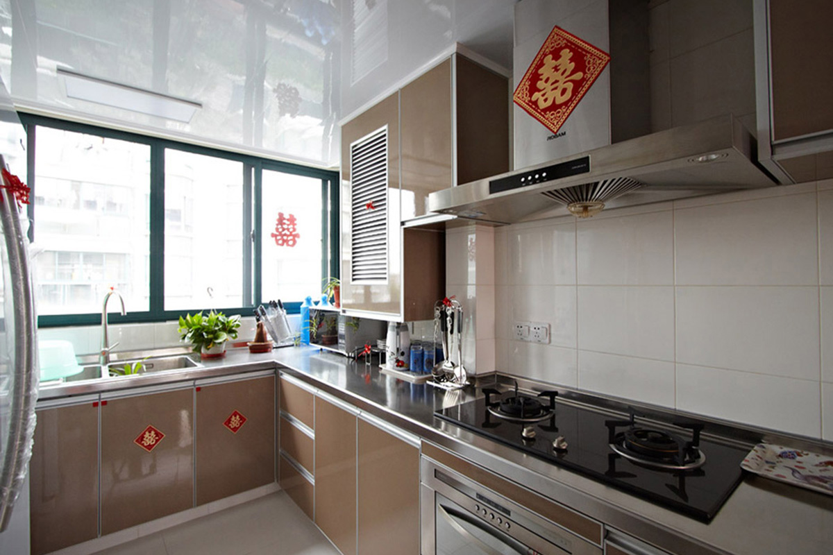 廚房墻磚白色，整體櫥柜采用今年比較流行的色彩“土豪金”，白色的空間加上香檳色的搭配，使得廚房狹小的空間得到視覺放大的體現(xiàn)。色彩中彰顯主人的高貴品味。
