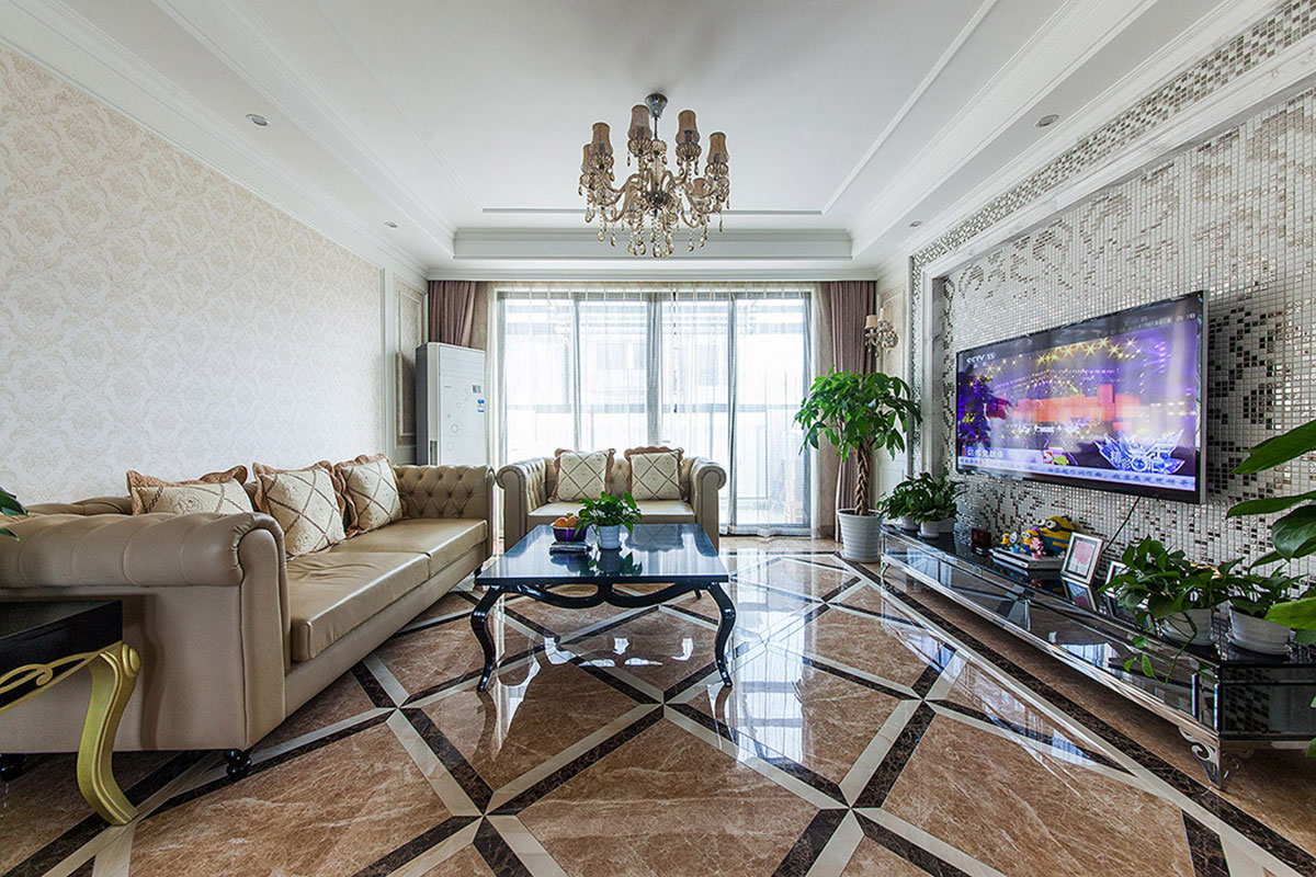 客廳可謂是簡(jiǎn)約卻不失奢華。經(jīng)典皮質(zhì)沙發(fā)大氣高貴，沙發(fā)兩側(cè)邊幾、茶幾、電視柜都以黑色呈現(xiàn)，背景墻的金色花紋馬賽克，頓時(shí)客廳顯得高大上起來(lái)。