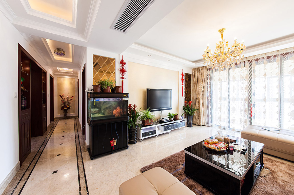 鏡面的巧妙利用使得客廳的整體空間視覺加大，漂亮的水晶吊燈，深色的茶幾給人一種輕飄而又穩(wěn)重的視覺感受。