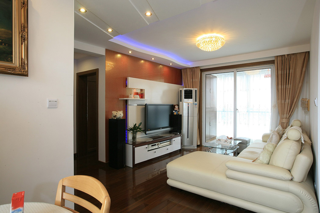 客廳整體簡潔大方，米色舒適的沙發(fā)，干凈時尚。背景墻是業(yè)主的最愛，橙色烤漆玻璃與白色烤漆板結(jié)合現(xiàn)代時尚
