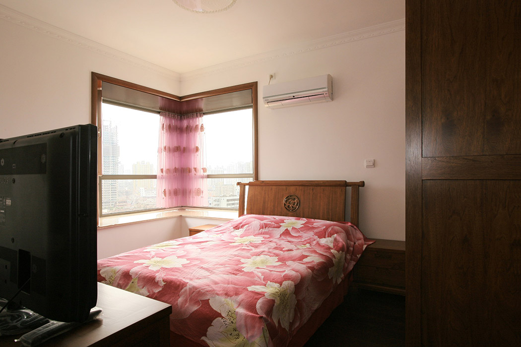 臥室里以白色為主色調，一張中式的床，加上兩只床頭柜