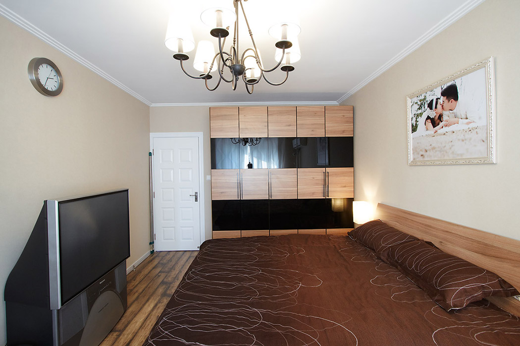 主臥室的墻面用了時尚的米黃色色系，和木紋色的衣柜多了種層次感。
