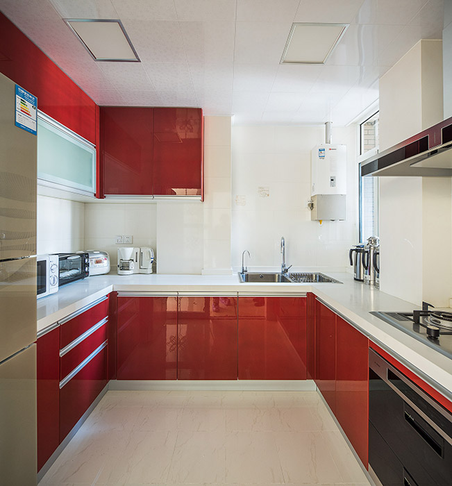 廚房墻磚白色，整體櫥柜采用紅色系來體現作為婚房的主題，白色的空間加上紅色的搭配，淺色的地磚和淺色的吊頂形成呼應，使得廚房狹小的空間得到視覺放大，彰顯主人的高貴品味。
