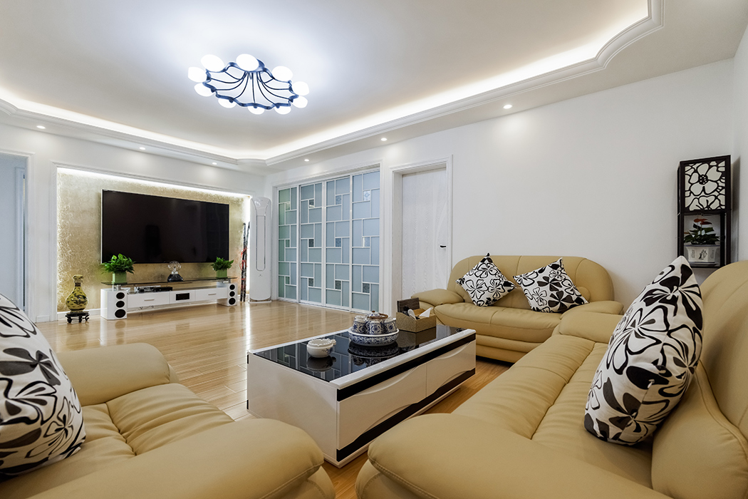 客廳為了配合業主家的米色沙發，地面采用了淡色系的復合地板，家具采用黑白系列，簡單干凈。沒有過多的裝飾，通過頂面的弧線設計，讓整個客廳顯得不那么單調。
