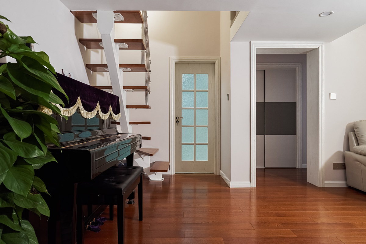 客廳為了配合業主家的米白色沙發，地面采用了環保的實木地板，家具采用黑白系列，簡單干凈。沒有過多的裝飾，頂面沒有做過多的修飾主要考慮到業主的房型是loft，需要搭建，吊頂的話會壓低層高也會使人不舒服所以頂面不做過多裝飾。電視背景墻采用灰色的地板上墻，給人以穩重的感覺，客廳樓梯采用的是經濟實用的鋼木樓梯，同時讓整個客廳顯得不那么單調。
