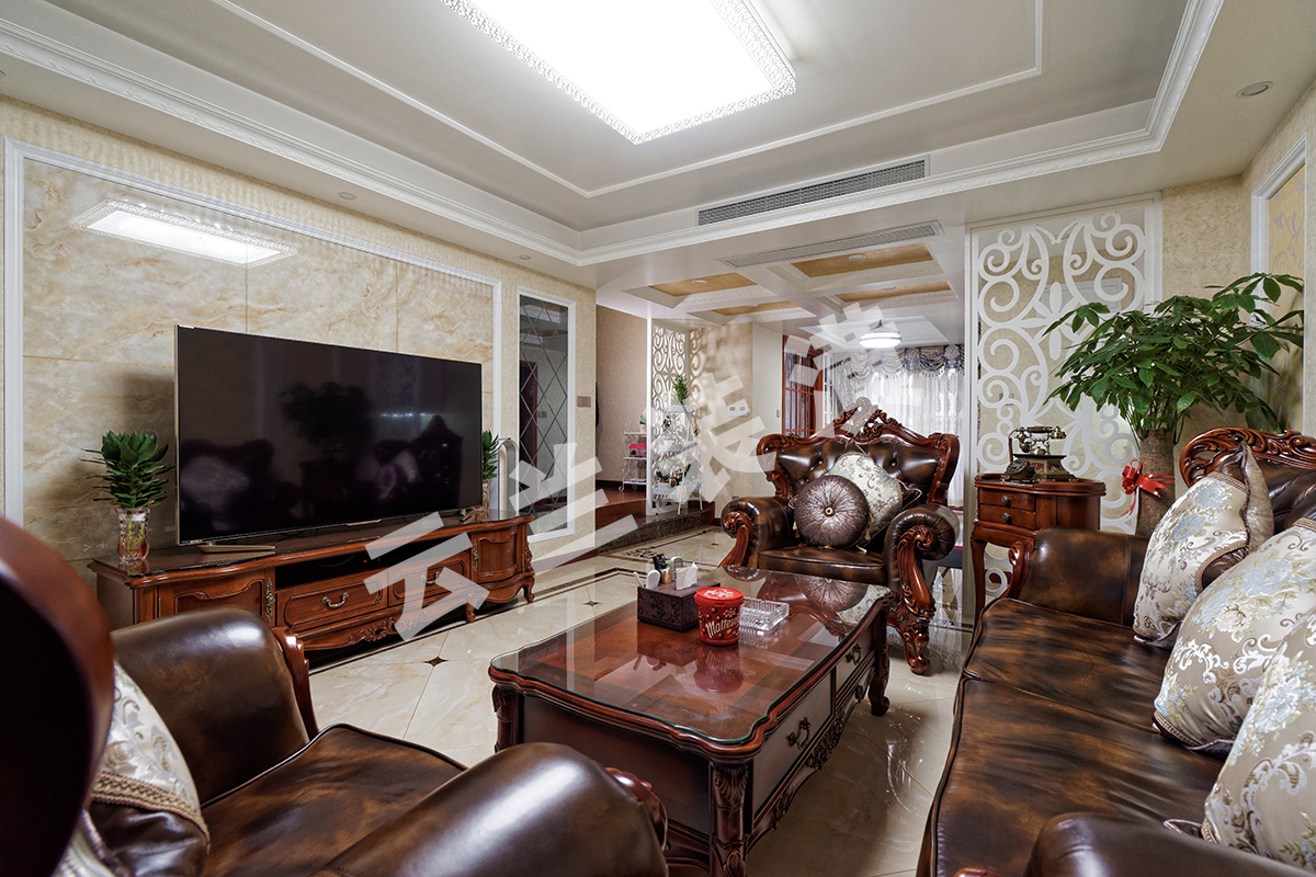 客廳為了襯托沉穩(wěn)大氣的深色家具，客廳采有光潔大氣的地磚，使得深色家具不再壓抑，也更凸顯了家具的質感，品質生活油然而生。歐式家具低調而奢華，沉穩(wěn)而大氣，充分體現(xiàn)了業(yè)主的，低調而內斂的做人風格。電視背景墻的線框采用的實木線條，中間采用的是當下比較流行的微晶石，兩邊菱形抽邊境，顯得端莊大氣。
