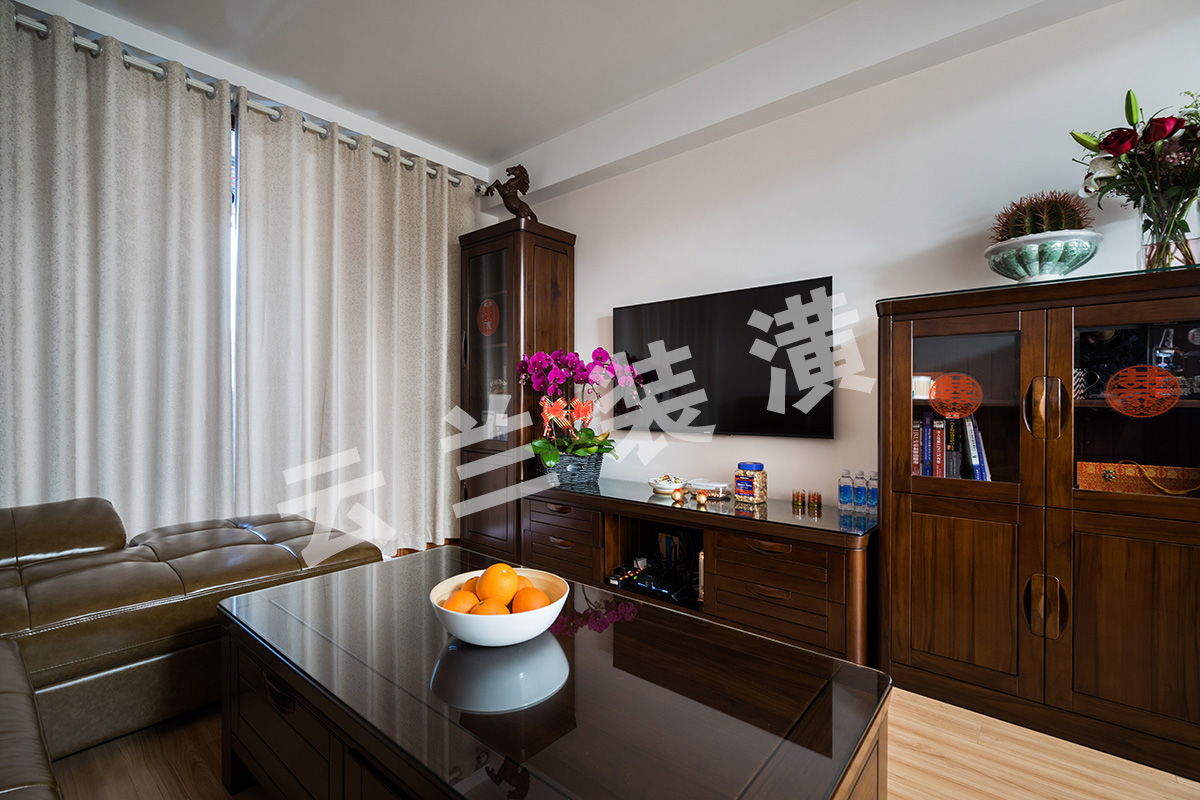 客廳為了襯托沉穩大氣的深色家具，客廳采用淺色地板，使得深色家具不再壓抑，也更凸顯了家具的質感，品質生活油然而生。家具低調而奢華，沉穩而大氣，充分體現了業主的，低調而內斂的做人風格。
