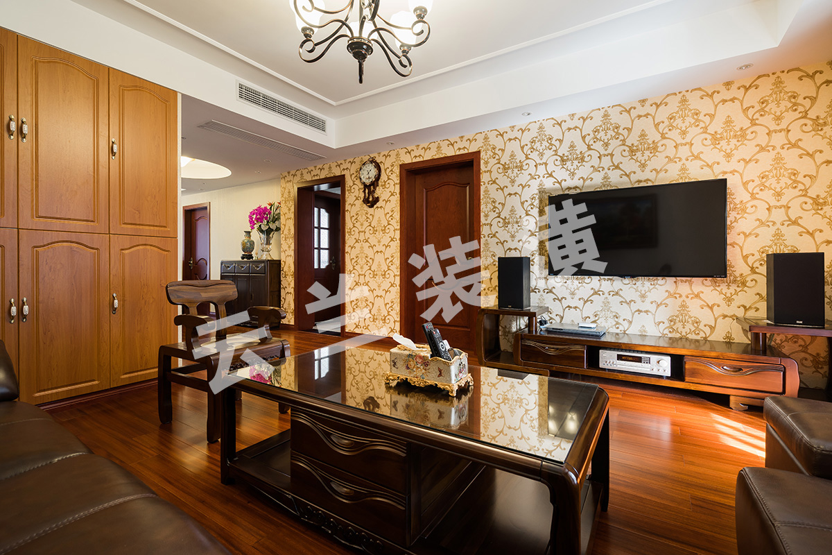客廳為了襯托沉穩大氣的深色家具，客廳采有圓盤豆實木地板，與家具相映成趣，不突兀！廳里也考慮家里儲物空間的需要，配相對應顏色柜門，也成家里一道亮點！背景墻面，沒有做過多的繁瑣造型，而是通過墻布做出底色承托，因為背景墻面與主臥室門比較接近，所以我們也采用將門納入背景，使得背景更加大氣。
