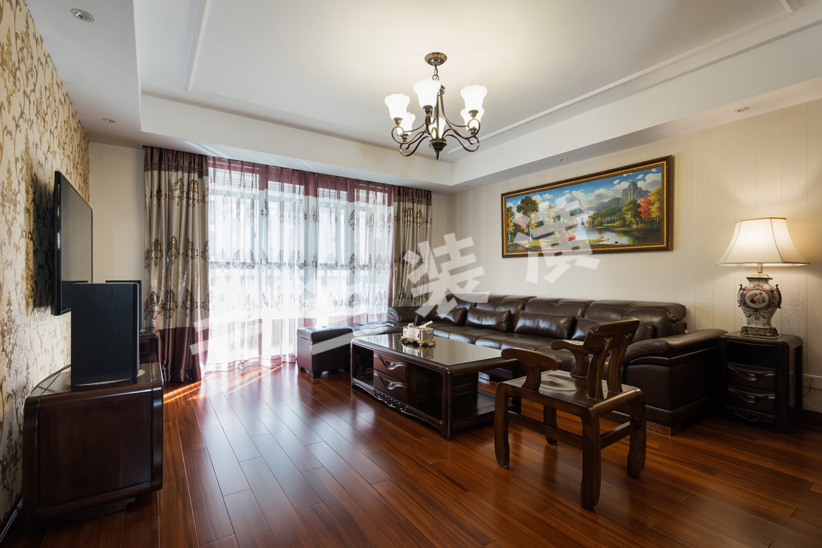 客廳為了襯托沉穩大氣的深色家具，客廳采有圓盤豆實木地板，與家具相映成趣，不突兀！廳里也考慮家里儲物空間的需要，配相對應顏色柜門，也成家里一道亮點！背景墻面，沒有做過多的繁瑣造型，而是通過墻布做出底色承托，因為背景墻面與主臥室門比較接近，所以我們也采用將門納入背景，使得背景更加大氣。
