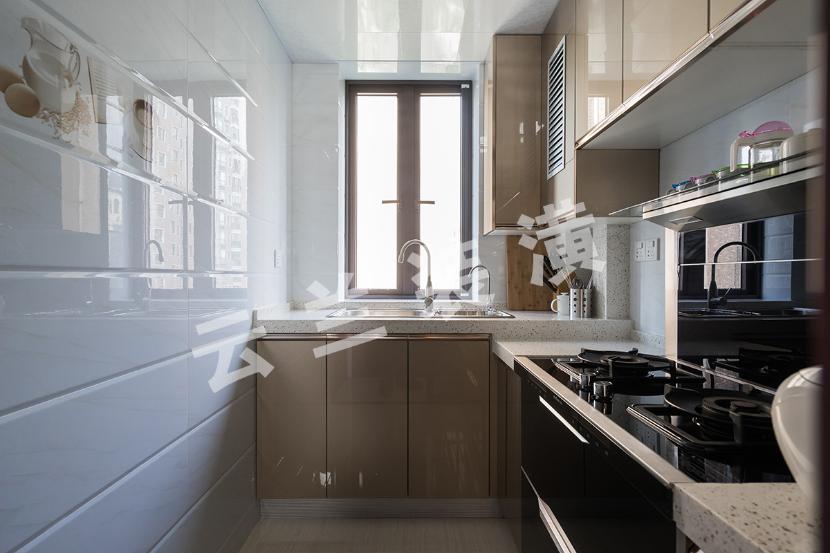 廚房瓷磚采用淺色打底，凸顯廚衛，使空間看上去更有層次。櫥柜采用的香檳色晶鋼板，方便打理也更加耐用，房東灶具選用的一體集成灶，功能集成，空間更高效
